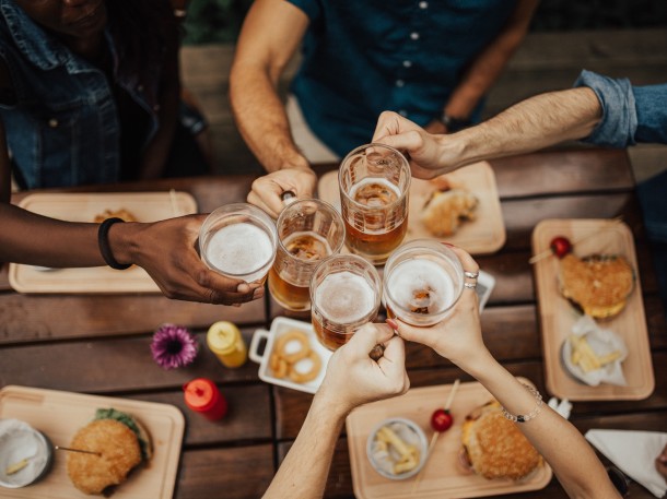 group of friends cheersing beer with burgers